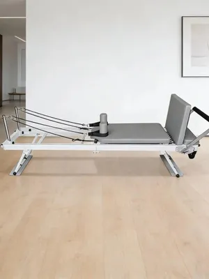 Produktbild von Pilates Reformer - Heimtrainer - Klappbar - Verstellbarer Widerstand - Federn und Pedal - Stahlrahmen - Core- und Ganzkörpertraining - Beige