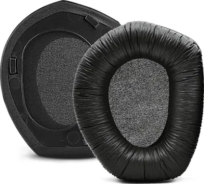 Two black ear pads for headphones are shown against a white background. One ear pad is shown from the back, revealing its plastic mounting base. The other ear pad is shown from the front, with its cushioned, faux-leather exterior and fabric interior.