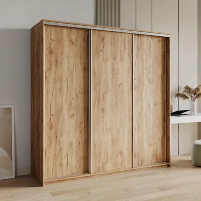 A wooden wardrobe with sliding doors in a room.