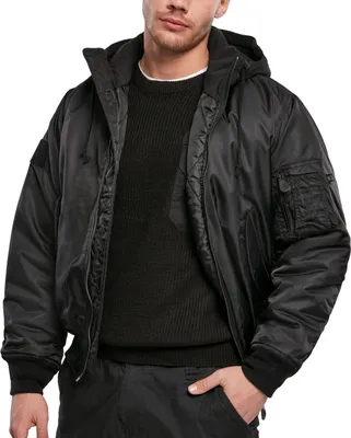 A man wearing a black bomber jacket with a hood and a black sweater.