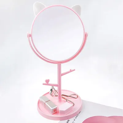 A pink makeup mirror with cat ears and a tray for cosmetics.