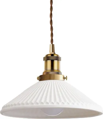 A pendant light fixture with a white ceramic shade and brass accents, suspended by a brown cord.