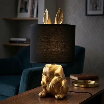 Immagine prodotto di Lampada da tavolo a forma di coniglio, in resina e tessuto, dimensioni 20x43 cm, colore oro e nero, design Mauro Ferretti
