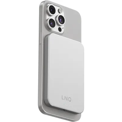 A silver smartphone with a silver magnetic wireless power bank attached to its back.