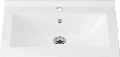 A top-down view of a white ceramic sink with a faucet hole and drain.