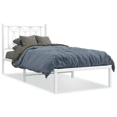 A white metal bed frame with a decorative headboard, shown with bedding.