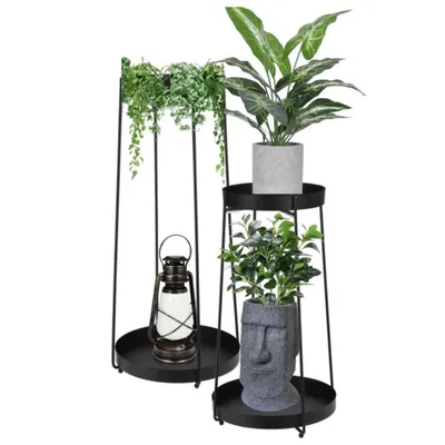 Two black metal plant stands with plants and a lantern.