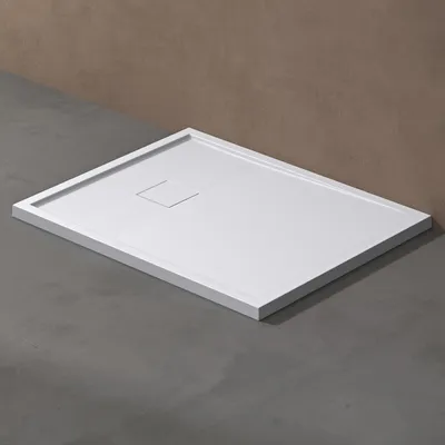 A white shower tray is shown on a gray floor with a brown wall in the background.