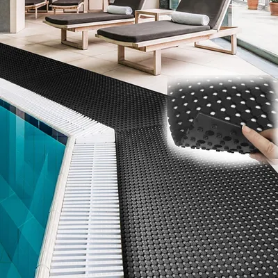 A black anti-slip mat is laid out next to a swimming pool.