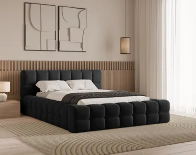 A bedroom scene featuring a black upholstered bed with white bedding and decorative wall art.