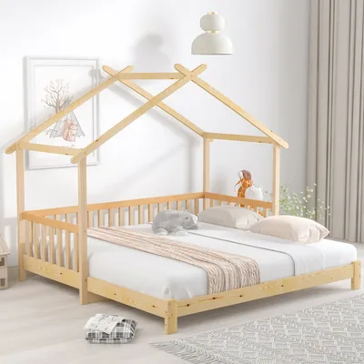 A wooden house-shaped bed frame with a mattress and bedding in a room.