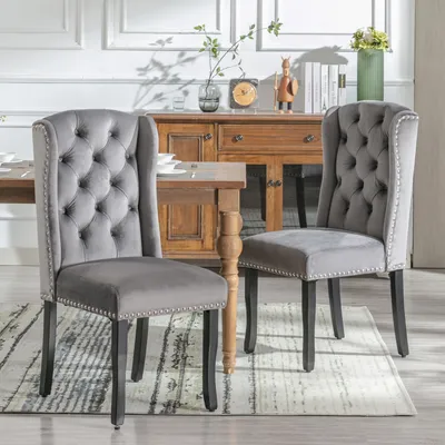 Two dining chairs are placed in a dining room setting, with a wooden sideboard in the background.