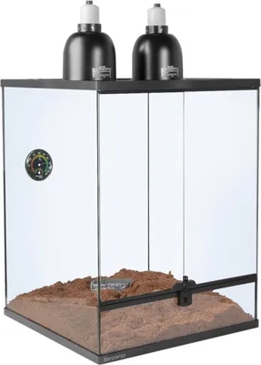 A terrarium with two heat lamps on top, filled with substrate.