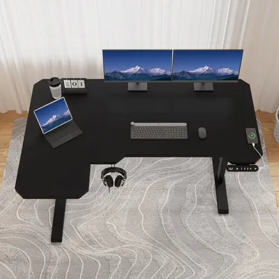 A black L-shaped standing desk with dual monitors, a laptop, keyboard, mouse, and headphones.