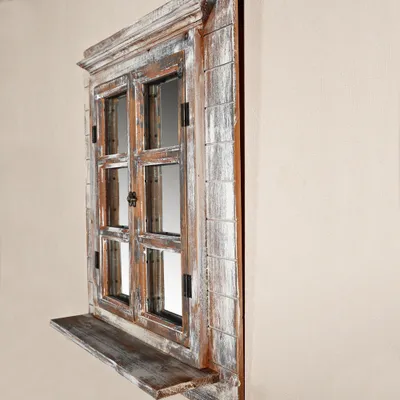 A decorative mirror designed to look like a window with shutters and a shelf.