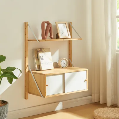 A wooden wall shelf with two shelves and a cabinet with two doors, decorated with books, a picture frame, and a small clock.