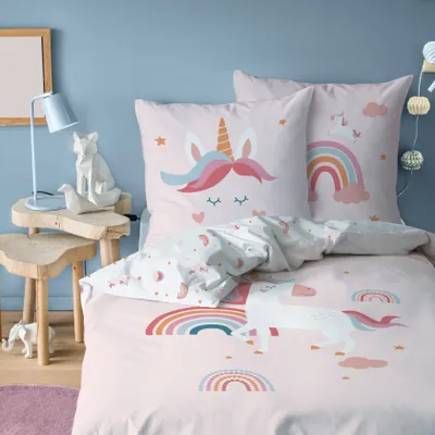 A child's bedroom with unicorn-themed bedding.