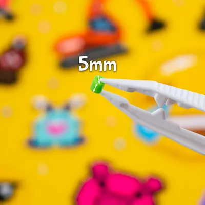 A close-up of a small green bead being held by tweezers, with the text '5mm' visible.