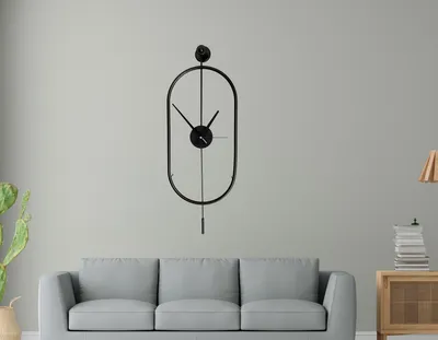 A modern living room with a gray sofa and a black metal wall clock.