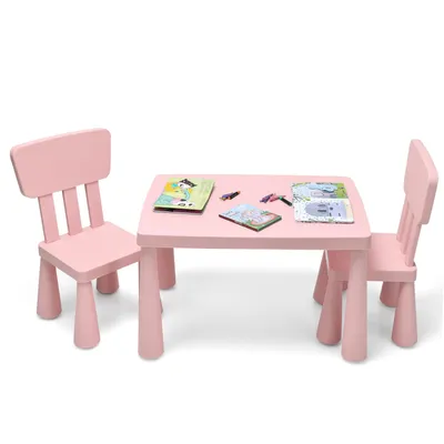 A pink children's table and two chairs set, with books and crayons on the table.