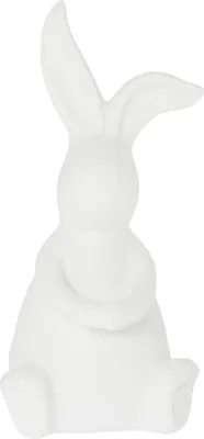 A white ceramic bunny figurine is shown from the back, sitting with its arms wrapped around itself.