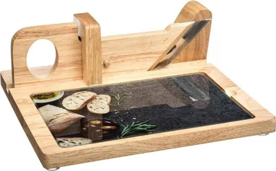 A wooden bread slicer with a stone cutting surface, shown with some bread and herbs.