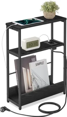 A narrow black side table with a charging station, a tablet, a digital clock, and a small plant.