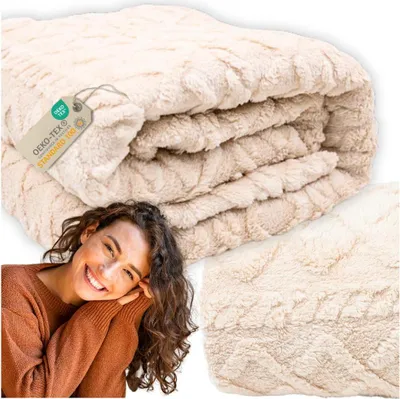 A woman smiling and leaning on her hands, with a folded blanket in the background and a close-up of the blanket texture in the lower right corner.
