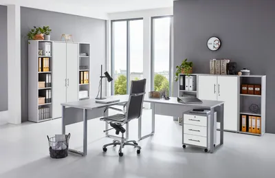 A modern office setup with a desk, chair, and storage units.