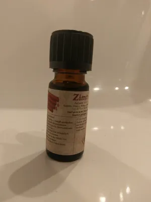 Kleine braune Flasche mit einem schwarzen Verschluss. Auf dem Etikett steht "Zimt".