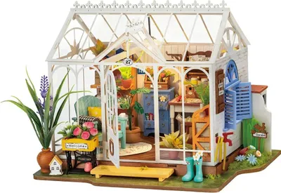 A miniature greenhouse model with detailed interior furnishings and plants.