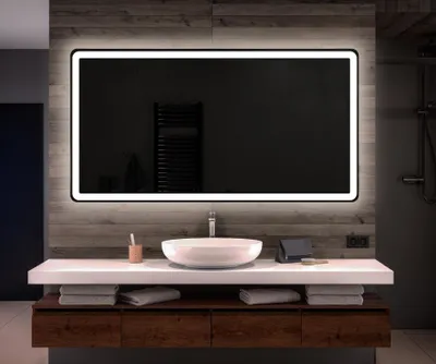 A modern bathroom vanity with a large illuminated mirror above a sink and wooden cabinets.