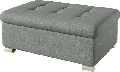A gray upholstered ottoman with tufted top and short wooden legs.