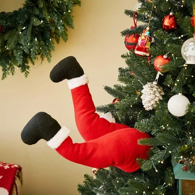 Image de Père Noël et pieds en peluche de couleur ivoire avec chaussures à fixer sur les décorations d'arbres de Noël. Décoration de jambes du Père Noël pour la décoration de la porte d'entrée de l'arbre de Noël