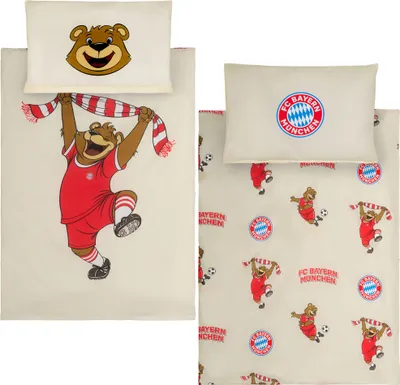 A split image showing two views of FC Bayern München themed bedding sets for babies or toddlers. The left side features a large illustration of a bear mascot holding a scarf, with a matching pillowcase. The right side shows a smaller, repeating pattern of 