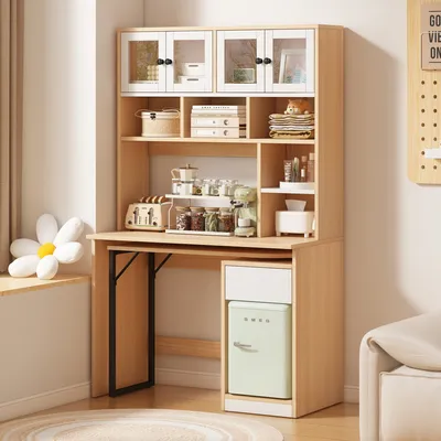A computer desk with shelves and a mini-fridge, set up in a room with natural light.