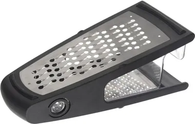 A close-up studio shot of a black and silver grater against a white background.