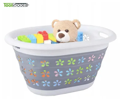 A collapsible laundry basket filled with toys and a teddy bear.
