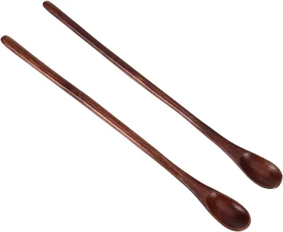 Two long wooden spoons are laid out diagonally on a white background.