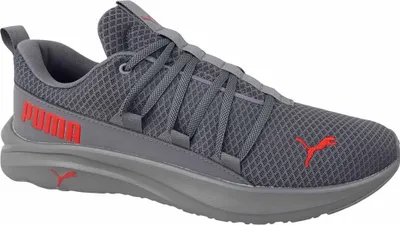 A side view of a gray Puma sneaker with red accents.