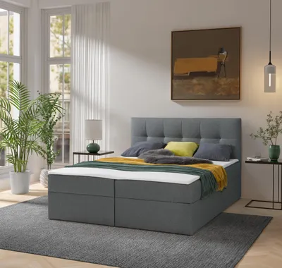 A bedroom scene with a bed, plants, and artwork.