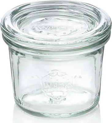 A clear glass jar with the brand name embossed on it.