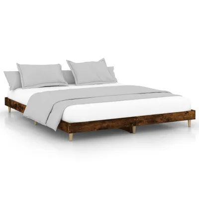 A bed frame with bedding and pillows, shown against a white background.
