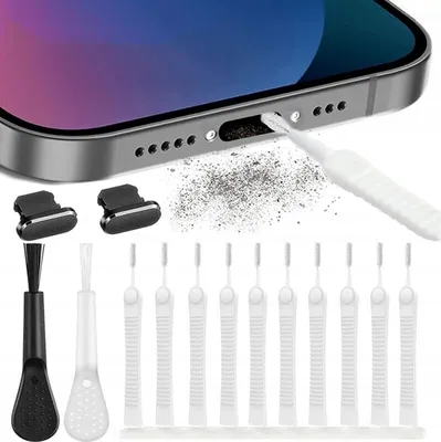 A close-up of a smartphone charging port being cleaned with a brush, with various cleaning tools laid out below.