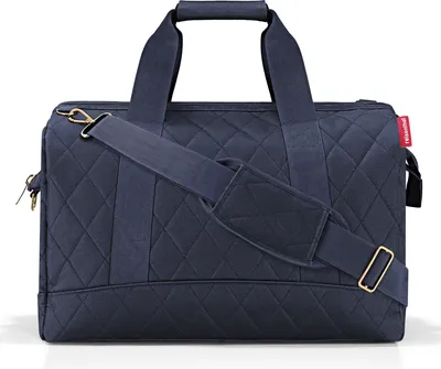 A studio shot of a blue quilted duffel bag.