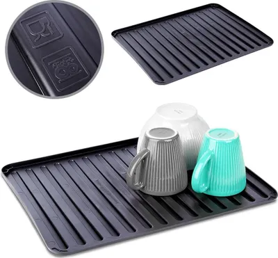 A black dish drying mat with cups and a bowl on it, with a close-up of symbols on the mat in the upper left corner.