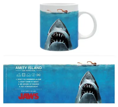 A mug with a Jaws movie theme, showing a shark and a swimmer, with care instructions and movie title on a separate strip below.