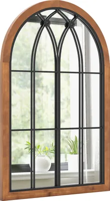 A mirror with a window-like design, featuring a wooden frame and black metal mullions, reflecting a window with plants on a windowsill.