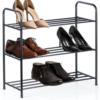 A three-tiered black metal shoe rack holding various shoes.