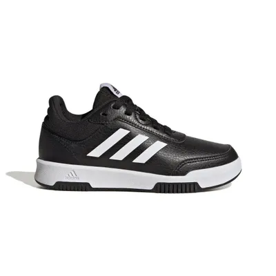 A black Adidas shoe with white stripes on a white background.